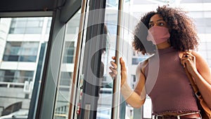 Young adult woman entering office wearing face mask