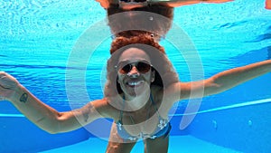 Young adult woman have fun and enjoy blue pool water in summer holiday vacation - nice middle age female people swim active and