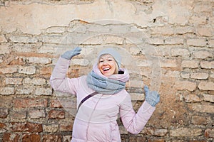 Young adult woman have fun on old brick wall background.