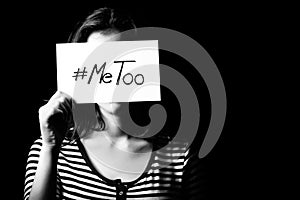 Young adult woman holding a sign with the hashtag MeToo