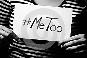 Young adult woman holding a sign with the hashtag MeToo