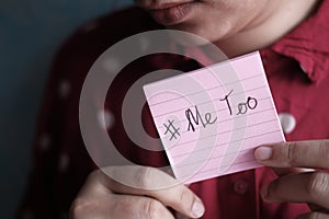 Young adult woman holding a sign with the hashtag MeToo