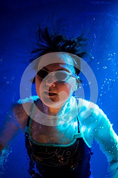 Young adult woman levitates in deep water