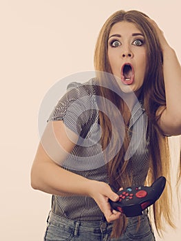 Shocked gamer woman holding gaming pad