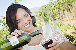 Young Adult Woman Pouring A Glass of Wine in Vineyard