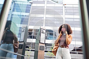 Young adult woman putting on face mask before entering office