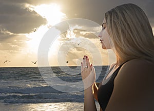 Young Adult Woman Relaxed Prayer Pose at Beach - Seagulls Orange Sunlight Sky Clouds Parting - Visual Meditation Yoga Zen -