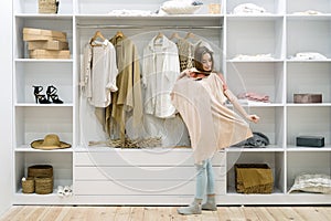 Young adult woman standing near wardrobe,  choosing wear