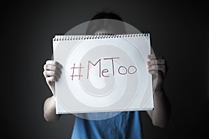Woman holding notebook with MeToo written on page photo