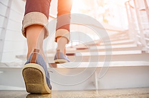 Young adult woman walking up the stairs