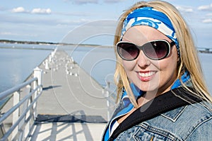 Young adult woman walks out onto a pier near the Choptank River in Cambridge Maryland on a sunny spring day photo