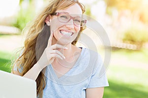 Professional Young Adult Woman Wearing Glasses Outdoors Using Her Laptop.