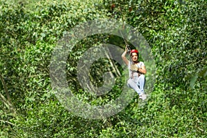 Young Adult Woman On Zip Line Over The Tree Canopy