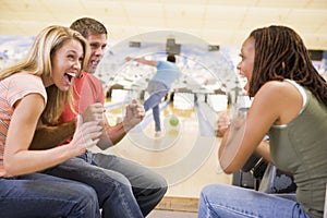 Young adults cheering in a bowling alley