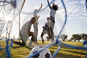 Young adults cheering a scored goal at football game