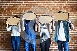 Young adults holding up copyspace placard thought bubbles