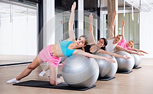 Young adults training pilates at group class