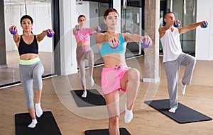 Young adults training pilates with toning balls