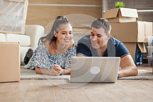 Young adults using their laptop in the new flat