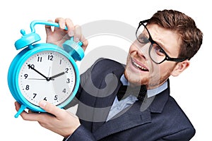 Young afraid man holding alarm clock