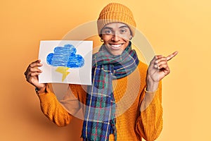 Young african amercian man holding thunder draw smiling happy pointing with hand and finger to the side