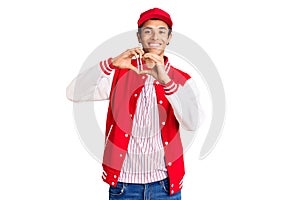 Young african amercian man wearing baseball uniform smiling in love doing heart symbol shape with hands