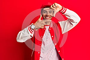 Young african amercian man wearing baseball uniform smiling making frame with hands and fingers with happy face