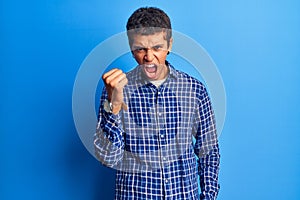 Young african amercian man wearing casual clothes angry and mad raising fist frustrated and furious while shouting with anger