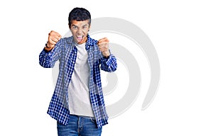 Young african amercian man wearing casual clothes angry and mad raising fists frustrated and furious while shouting with anger