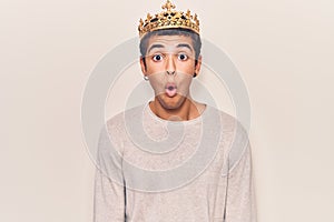 Young african amercian man wearing prince crown scared and amazed with open mouth for surprise, disbelief face