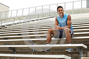 Teenage athlete sitting on the bleachers. photo