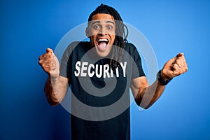 Young african american afro safeguard man with dreadlocks wearing security uniform screaming proud and celebrating victory and