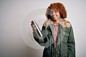 Young African American afro tourist woman with curly hair holding thermo with water with a happy face standing and smiling with a