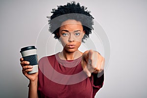 Young African American afro woman with curly hair drinking cup of coffee pointing with finger to the camera and to you, hand sign,