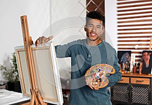 Young African-American artist painting picture at home