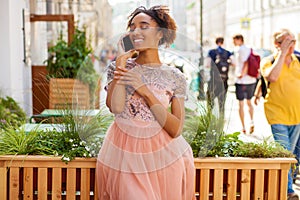 Young African American black woman in pink dress talking on cellphone