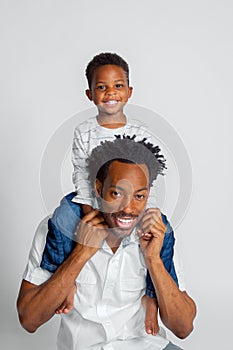 A Young African American Boy Sits Atop the Shoulders of His Dad photo