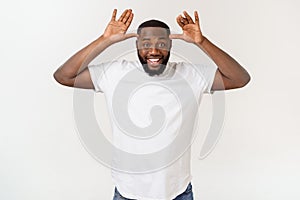 Young african american business man with smiling and laughing with hand on face covering eyes for surprise. Blind