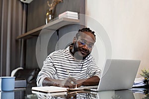 Young African American business man working with laptop and document on desk at home. work from home concept