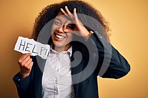 Young african american business woman with afro hair holding help paper for work stress with happy face smiling doing ok sign with