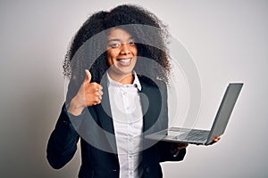 Young african american business woman with afro hair using computer laptop from job happy with big smile doing ok sign, thumb up