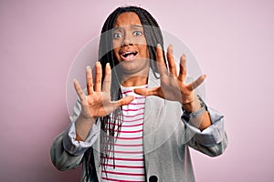 Young african american business woman standing over pink isolated background afraid and terrified with fear expression stop