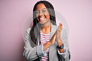 Young african american business woman standing over pink isolated background clapping and applauding happy and joyful, smiling
