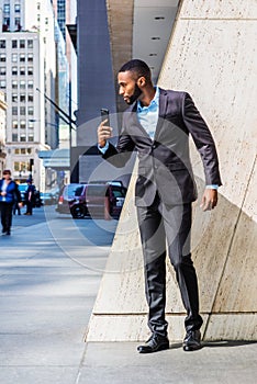 Young African American Businessman with beard self recording speech on cell phone outside office building in New York City