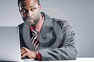 Young African American Businessman Being Sneaky On Laptop