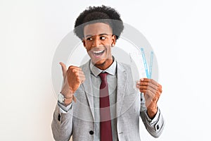 Young african american businessman holding boarding pass over isolated white background pointing and showing with thumb up to the