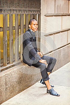 Young African American businessman relaxing on street in New York City