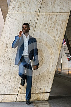 Young African American Businessman talking on cell phone outside