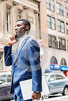 Young African American businessman talking on cell phone, traveling, working in New York