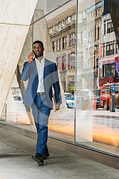 Young African American businessman talking on cell phone, traveling, working in New York